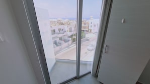 Vista desde un balcón con una calle despejada y edificios al fondo.