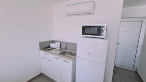 A compact kitchenette with a microwave, toaster, and sink.