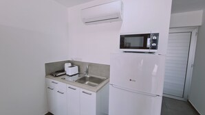 Une petite cuisine équipée d’un four à micro-ondes, d’un grille-pain et d’un évier.
