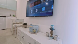 A modern kitchen with a flat-screen TV mounted on the wall displaying various apps. - STAY Napa Oasis Studio (Ayia Napa)