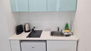 A compact kitchenette with a coffee maker, kettle, and a small dish rack. - STAY Napa Oasis Studio (Ayia Napa)