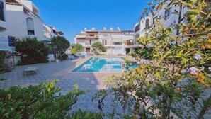 Une cour avec une piscine, entourée d’immeubles dotés de balcons et d’antennes paraboliques.
