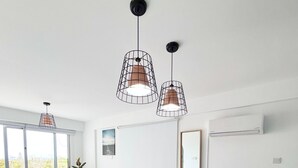 Een moderne keuken met een centraal eiland, hanglampen en uitzicht naar buiten.