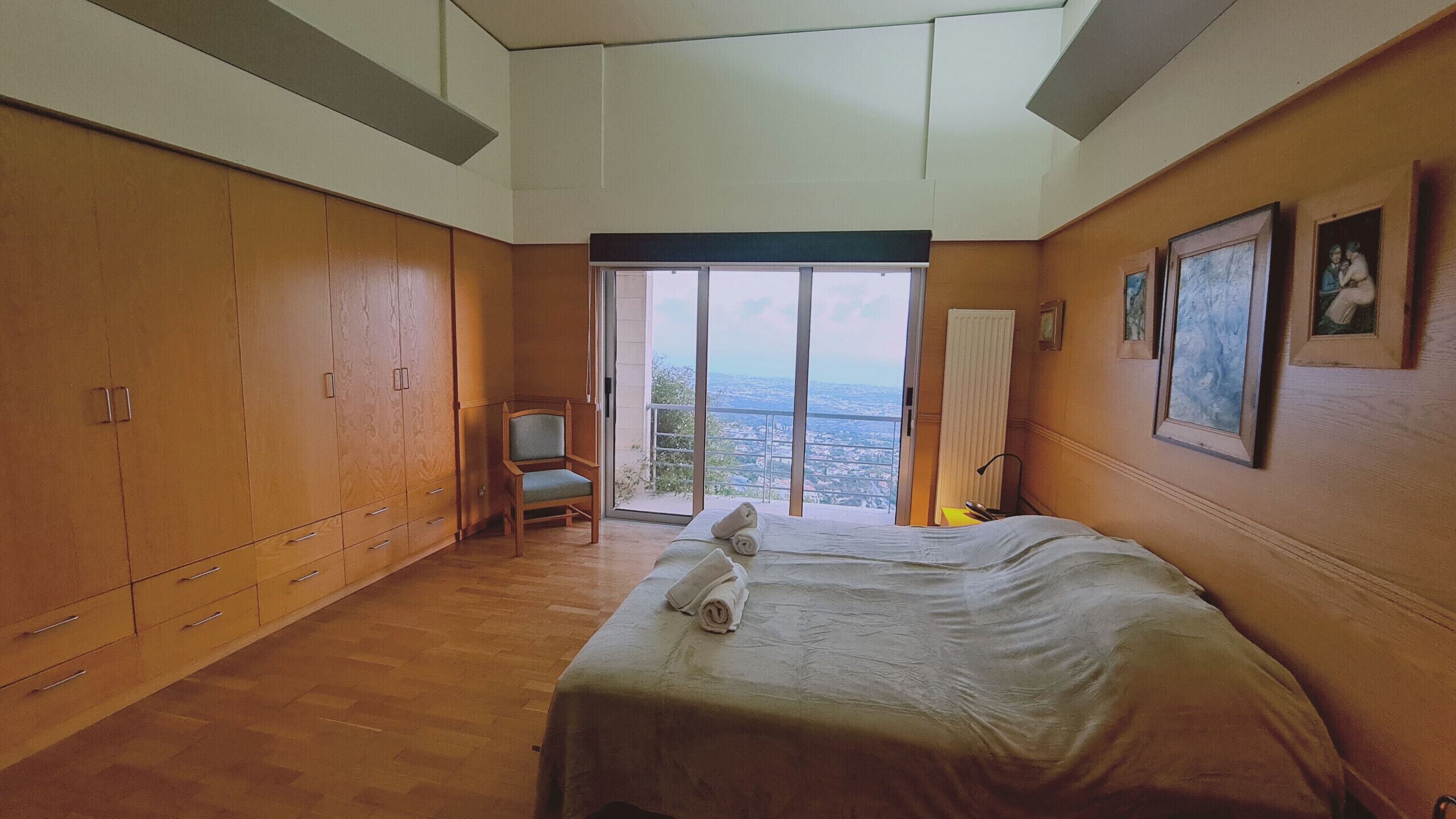 Ein Schlafzimmer mit einem großen Bett, einem Holzschrank und einem Stuhl.