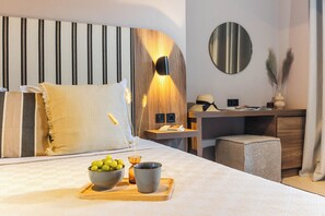 A modern hotel room with a large bed, a desk, and a small seating area. - Casa Blue Hotel Philian Collection (Skiathos)