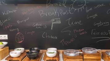 A chalkboard with breakfast options and a kitchen counter with bowls and containers.