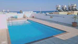 Una piscina en la azotea con vistas despejadas al mar.