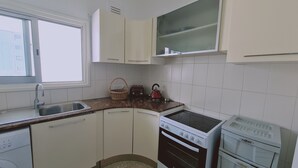 A kitchen with white cabinets, a sink, a stove, and a toaster. - STAY Antique Apartment (Larnaca)