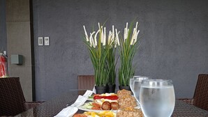 A table with a meal, a glass of water, and two potted plants. - DE PORCH (Bolinao)