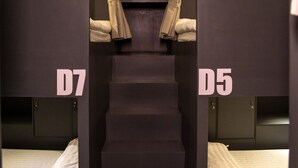 A corridor with four beds labeled D5, D6, D7, and D8, leading to a staircase. - Remedy Hostel (Vientiane)