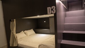 A modern room with a bed, a staircase, and a door marked D3. - Remedy Hostel (Vientiane)