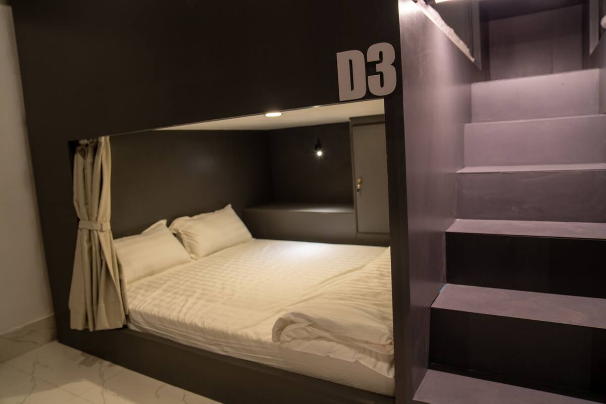 Una habitación moderna con una cama, una escalera y una puerta marcada D3.