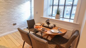 A dining area with a table set for four, including plates, cutlery, and a coffee pot. - Spring Rose (Bedale)