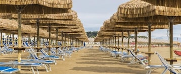 Playa privada, sillas reclinables de playa, sombrillas