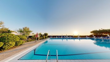 Una piscina al aire libre de temporada, sombrillas