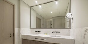 A bathroom with two sinks, a large mirror, and a cabinet below.