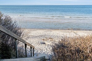 A beach with a wooden walkway leading to the shore.