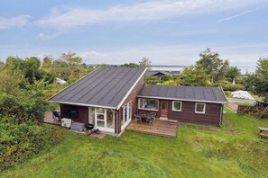 Een tweelaags huis met een terras, een patio en uitzicht op het omliggende landschap.