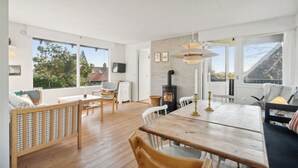 Un salón espacioso con una mesa de comedor de madera, sillas, un sofá y una chimenea.