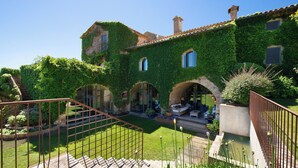 A building with ivy-covered walls, a stone staircase, and a small garden area. - Casa Rufina- Exclusiva Propiedad en el Corazón de Pals- Costa Brava (Pals)