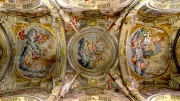 A grand hall with ornate ceiling frescoes and classical architectural elements.