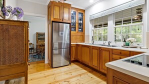 Cocina moderna con armarios de madera, refrigerador de acero inoxidable y un amplio ventanal con vistas al exterior.