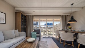 Ein modernes Wohnzimmer mit Sofa, Couchtisch und Essbereich mit Stühlen und Tisch.