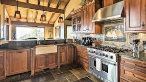A spacious kitchen with wooden cabinets, a large stove, and a window overlooking a scenic view.