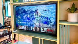 A TV mounted on a wall with a screen displaying a movie scene. - Studio apartment  Private bathtub, balcony, 45m2
 (Thành phố Hội An)