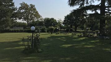 Un espace verdoyant bien entretenu, avec des arbres et un lampadaire.