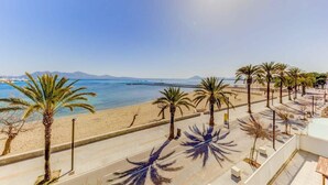 Vista de una playa con palmeras, arena dorada y un mar azul cristalino.