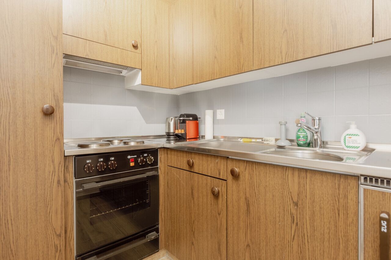 Une cuisine avec des armoires en bois, une cuisinière en acier inoxydable et un évier.