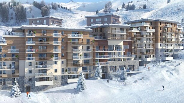 Ett hotell med flera våningar och balkonger, beläget med en snötäckt bergskedja som bakgrund.