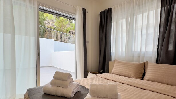 Une chambre d’hôtel avec un lit, un balcon et une vue sur l’extérieur.