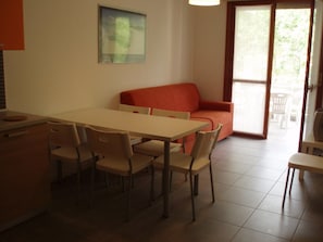 Zona pranzo con tavolo e sedie, un divano e una finestra con vista.