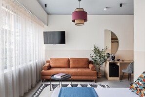 A modern living room with a sofa, coffee table, and a desk with a chair. - Airio Athens Suites (Athens)