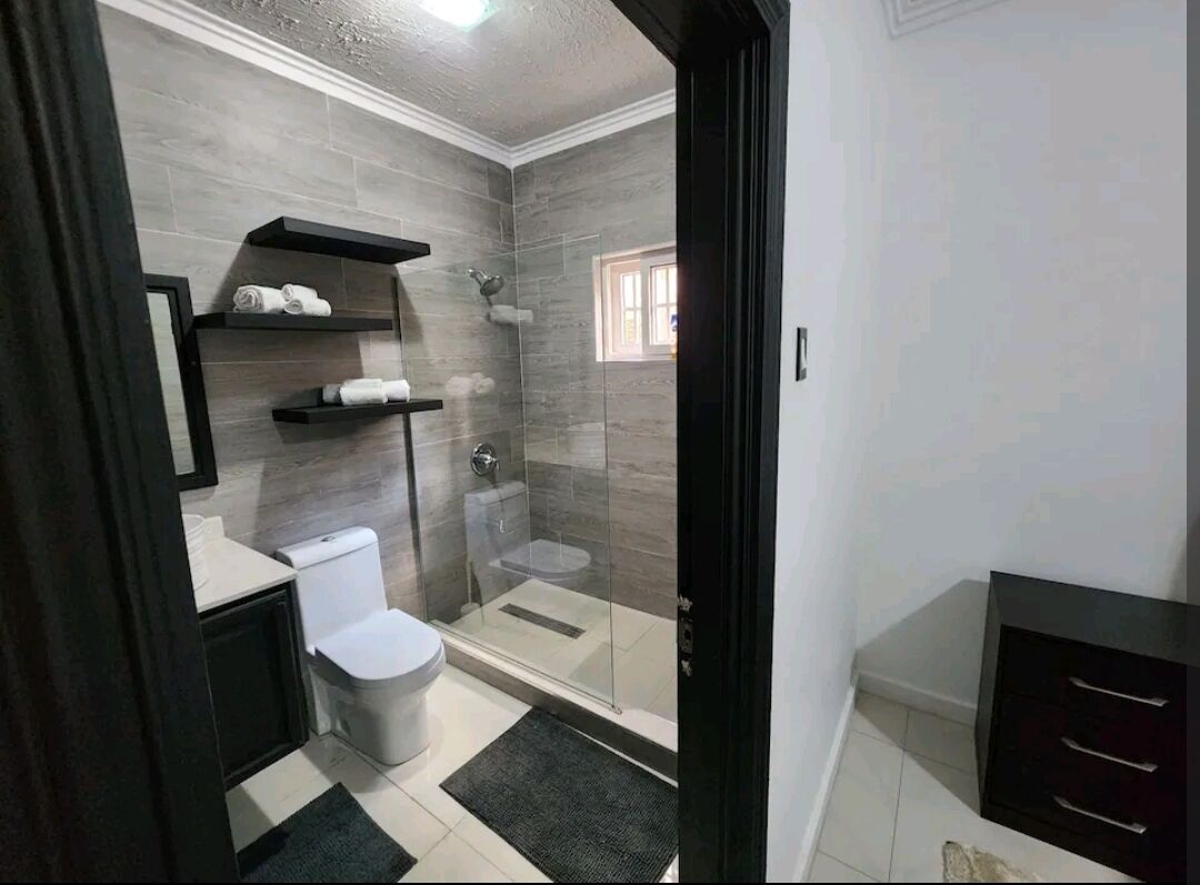 A modern bathroom with a toilet, sink, and shower area.