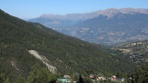 A mountainous landscape with a valley, houses, and a clear sky.