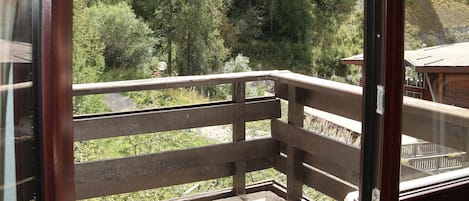 A balcony with a view of a forested area.