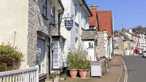 A traditional building with a sign for 'The Old Lace Shop' and a nearby shop advertising T-shirts. - The Old Lace Shop (Seaton)