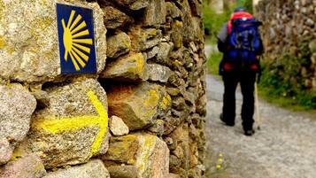A stone wall with a yellow sun symbol and a directional arrow.