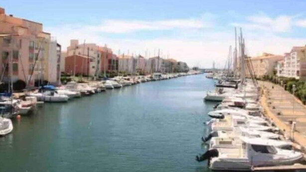 A marina with boats docked along a canal, surrounded by buildings. - Cosy Studio Port Cap D'agde (Agde)
