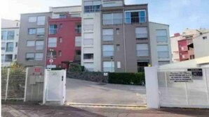 A multi-story residential building with a gated entrance, multiple balconies, and a mix of window styles. - Cosy Studio Port Cap D'agde (Agde)
