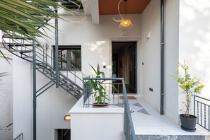 A modern interior with a staircase, potted plants, and a pendant light. - Villa Vesta - Kalamata Mediterranean Suites & Villas (Kalamata)