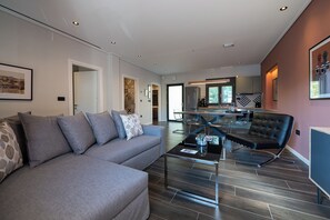 Un salon moderne avec un canapé, une table basse et un coin repas avec des chaises.