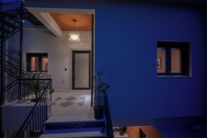 Un intérieur moderne avec un escalier, une plante en pot et un luminaire suspendu.