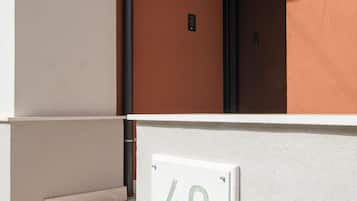 A building entrance with a sign reading '40 Villa Vesta,' steps leading up to the entrance, and a door with a black frame.
