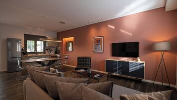 Un salon moderne avec un canapé, une table basse et un téléviseur à écran plat.