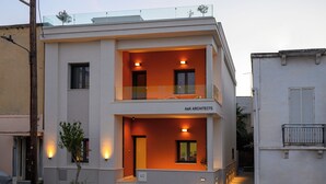 A two-story building with a balcony on the upper floor, a sign reading "A&K Architects," and a small tree in front. - Villa Vesta - Kalamata Mediterranean Suites & Villas (Kalamata)