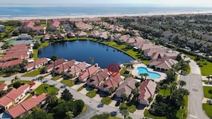 A residential area with a large lake, a swimming pool, and a beach in the background. - Beachside Bliss – Renovated Private Home in Sea Place Community with Resort (St. Augustine)